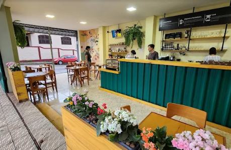 Salão aconchegante do Cafézin Lounge com balcão e plantas
